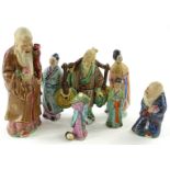 A collection of mainly souvenir oriental ceramic figures, to include immortals, figure carrying