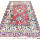 An Eastern rug, with a design of multi-coloured medallions, on a red ground with numerous borders,