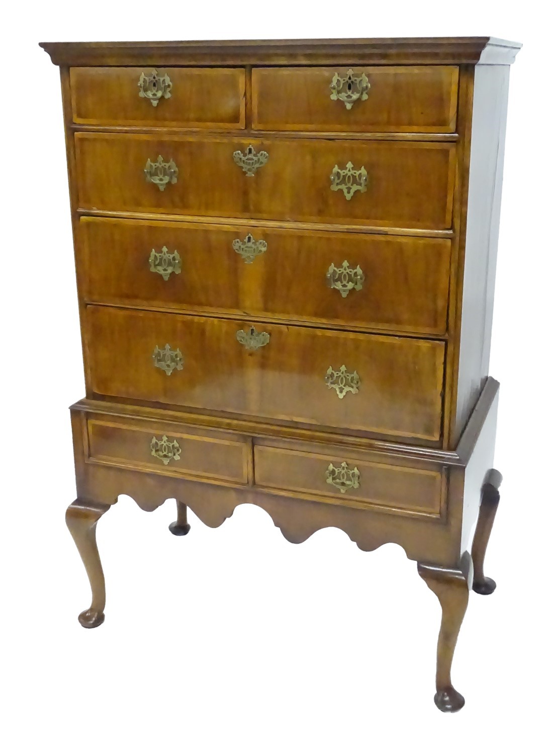 A walnut chest on stand, with a moulded cornice above two short and three long ash cross-banded