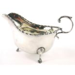A George V silver sauce boat, with a bead and real border on three feet, Birmingham 1929, 4¼oz.