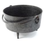 An early 20thC iron cauldron, of typical outline on shaped supports, with swing handle, 18cm H, 33cm