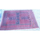 An Afghan style rug, with a central cross design on a deep pink ground with multiple borders,