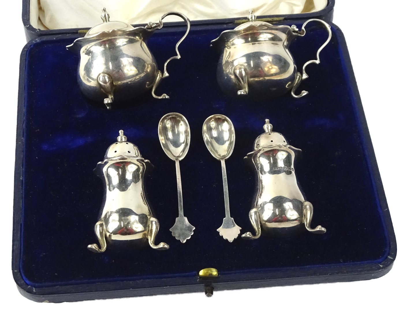 A Edward VII silver four piece cruet, comprising of a pair of mustard pots, each with a blue glass