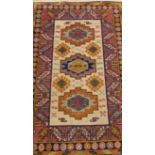 A machine woven Persian style rug, with a design of three medallions, on a cream ground with