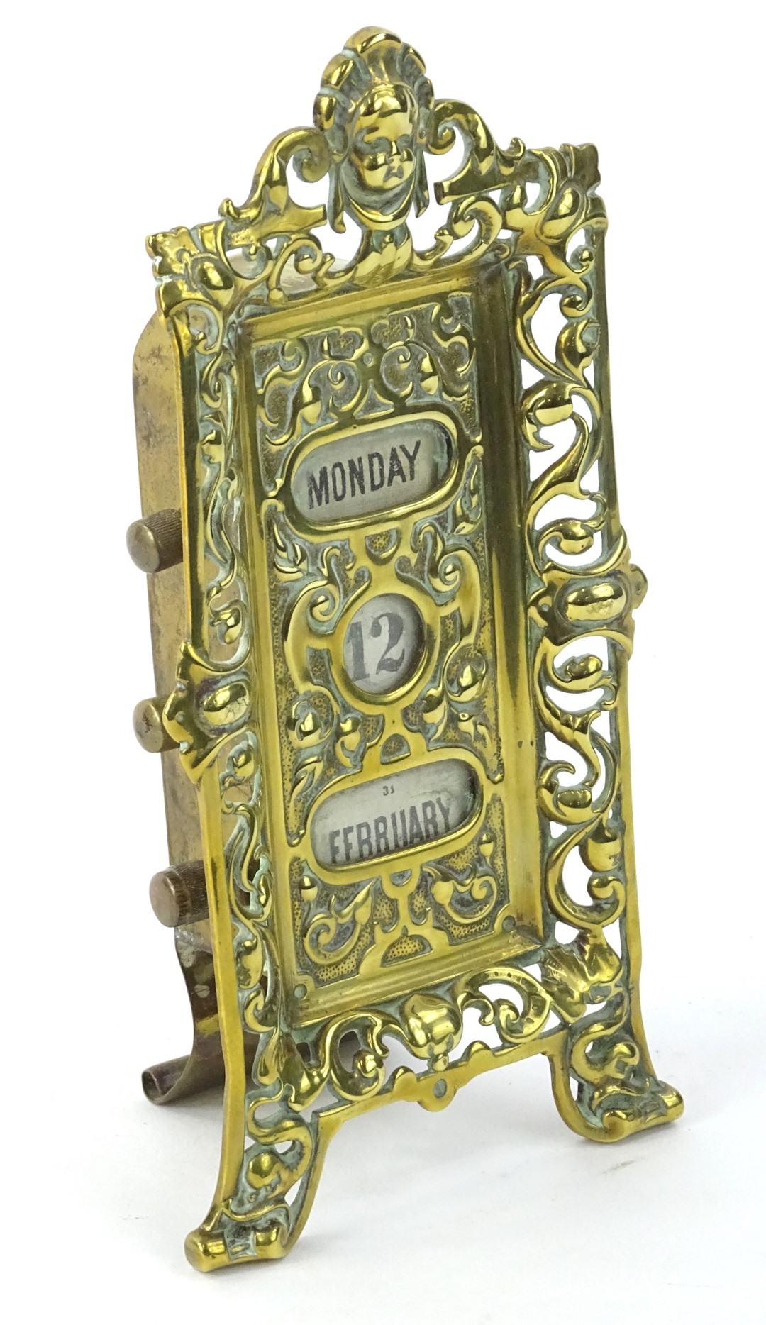 An Edwardian brass desk calendar, with pierced border and revolving drums, 20 cm H.