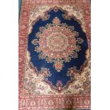 A machine woven wool carpet, in Persian style with a central floral medallion and multiple borders.