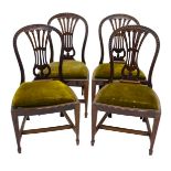 A set of four George III style mahogany dining chairs, each with a hooped carved back, a pierce