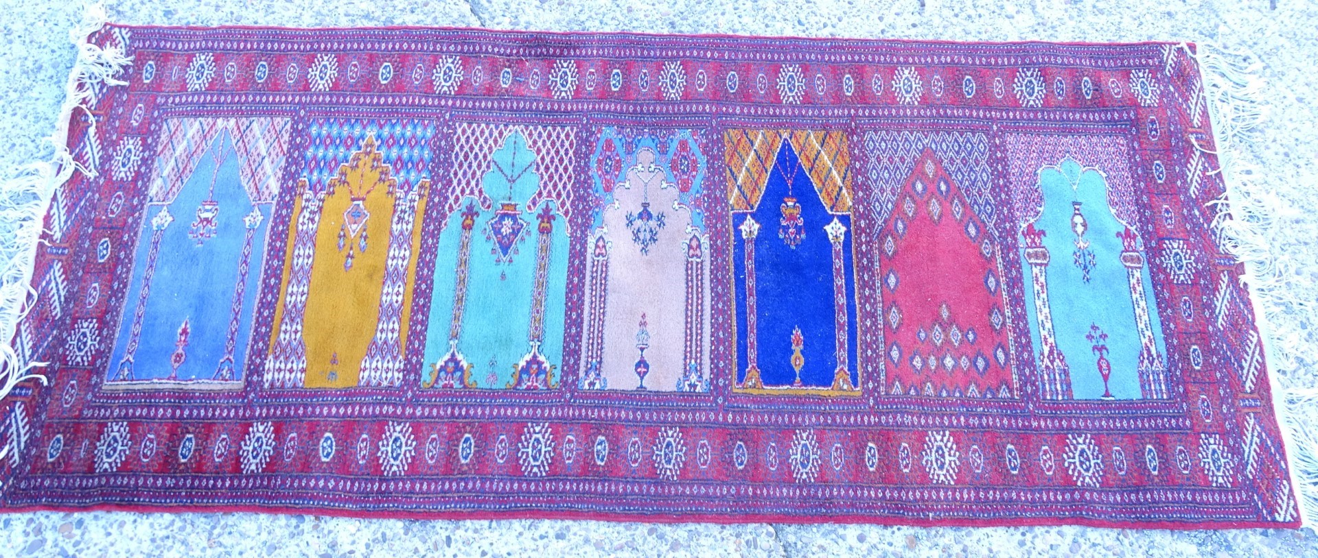 A Persian style multi mihrab prayer rug, with a design of windows, vases, etc. in multiple colours