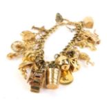 A 9ct gold and yellow metal charm bracelet, including aeroplane, horse's head, dinghy, etc., 59.3g.