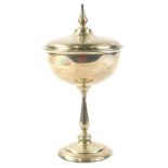 A George V silver covered chalice, the lid with a turned finial, on a facetted column and domed