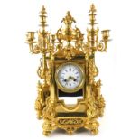 A French gilt brass clock garniture, the central clock cast with a central two handled urn,
