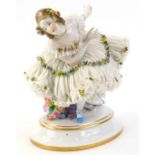 A Dresden porcelain crinoline figure, of a bowing ballet dancer, with flower encrusted embellishment