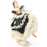 A Dresden porcelain crinoline Spanish dancer, on a rococo scroll base, 16cm H.