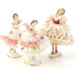 Three Dresden porcelain crinoline dancers, each with a pink and cream banded dress, the largest 17cm