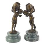 After Moreau, a pair of bronze figures of putti carrying vases, each on a marble base, 26cm H.