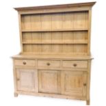 A 19thC pine dresser, the plate rack with three shelves below a moulded cornice, the base with an