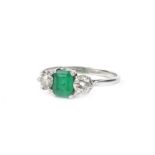 A platinum, emerald and diamond ring, in the Art Deco style, the central rectangular cut emerald