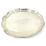 A Continental white metal salver, with pie crust border, engraved "Monsieur Armand Roger etc", dated