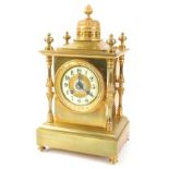 A French gilt brass mantel clock, with a central dome, surrounded by turned finials above a cream