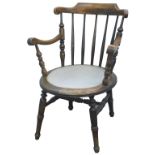 A 19thC ebonised beech Windsor chair, with spindled turn back, shaped arms and a padded circular