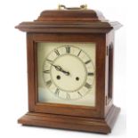 A German mantel clock, the printed dial with Roman numerals, in a mahogany case with brass