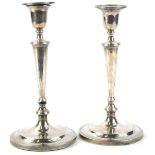 A pair of Edwardian silver candlesticks, each with tapering column, reeded sconce, loaded, 25¾oz