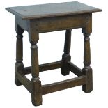 A 17thC oak joint stool, the top with a moulded edge, on turned supports, 50cm H, 49cm W, 29cm D.
