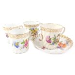 A small collection of Dresden cups, each decorated with flower sprays and a saucer