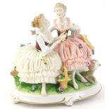 A German porcelain crinoline group, depicting two ladies seated beside a lamb, on a rococo scroll