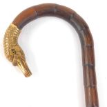 A late 19th/early 20thC walking cane, the handle with a cast yellow coloured metal, swan's head,
