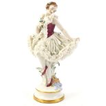 A large Dresden porcelain crinoline ballet dancer, with blue and pink flowers to her elaborate