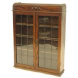 An early 20thC oak bookcase, with two leaded glazed doors, 77cm W.