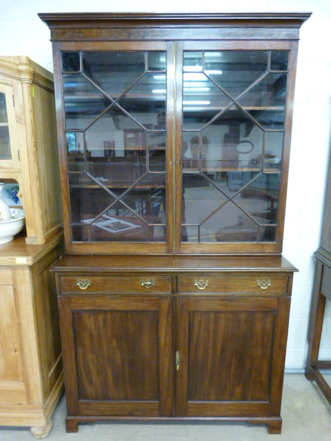 Mahogany 19th century bookcase with cupboards under, shaped frieze decoration sits above two