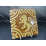 Encaustic terracotta tile decorated with the rampant Lion enclosed by a star and facing left.