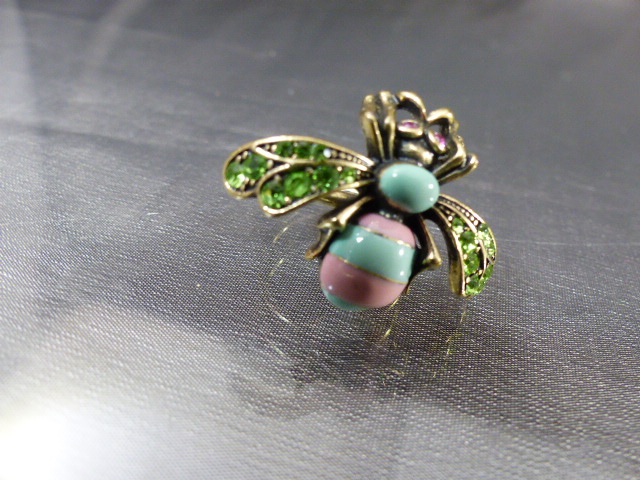Kitsch bug ring by 'Bohm' in pink and Turquoise enamel with green paste set wings and red eyes,