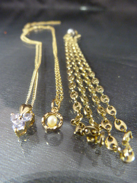 Three Gold coloured metal chains with pendants