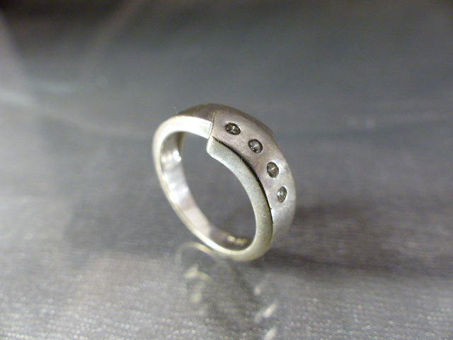 Silver 925 diamonds set ring. The stylised approx 5.5mm band overlapping design is set with 4