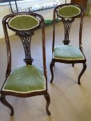 Pair of mahogany sloped arm bedroom chairs with carved floral splat in the Nouveau style