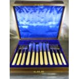 Oak cased set of 12 fish knives and forks with bone handles