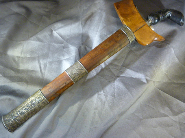 Kris Dagger with straight blade in a hardwood scabbard. The scabbard has silver coloured metal