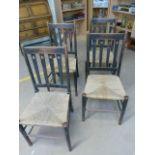 Set of four Arts and Crafts oak rush seated chairs with pierced slatted back.