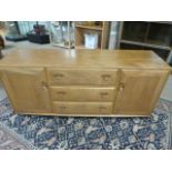 Ercol Blonde elm sideboard with three central drawers and two cupboards flanking.