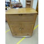 An Ercol light elm drinks cabinet with drop front and cupboard with single drawer