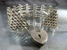 Pretty six bar gate bracelet with unusual 'cross-over' gates. Heart shaped padlock with safety chain