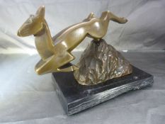Art Deco bronze deer of angular form leaping over a rock. On a black slate plinth with built in
