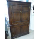 Late Georgian floor standing corner cabinet in Oak. Two panel doors with shelving interior below a