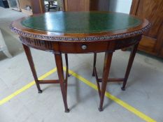 Oval mahogany antique occasional table with green toolwork leather inlay. Carved to outer top of