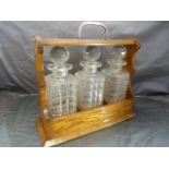 Oak cased Tantalus with three matching decanters. Monogrammed to lock F & WG