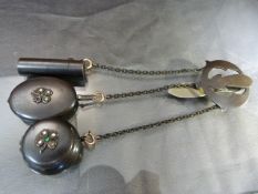 A Victorian Chatelaine in gun metal comprising a glass lined scent bottle, a mirror and a pot shaped