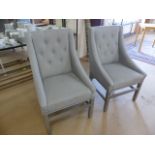 Two upholstered light grey contemporary armchairs